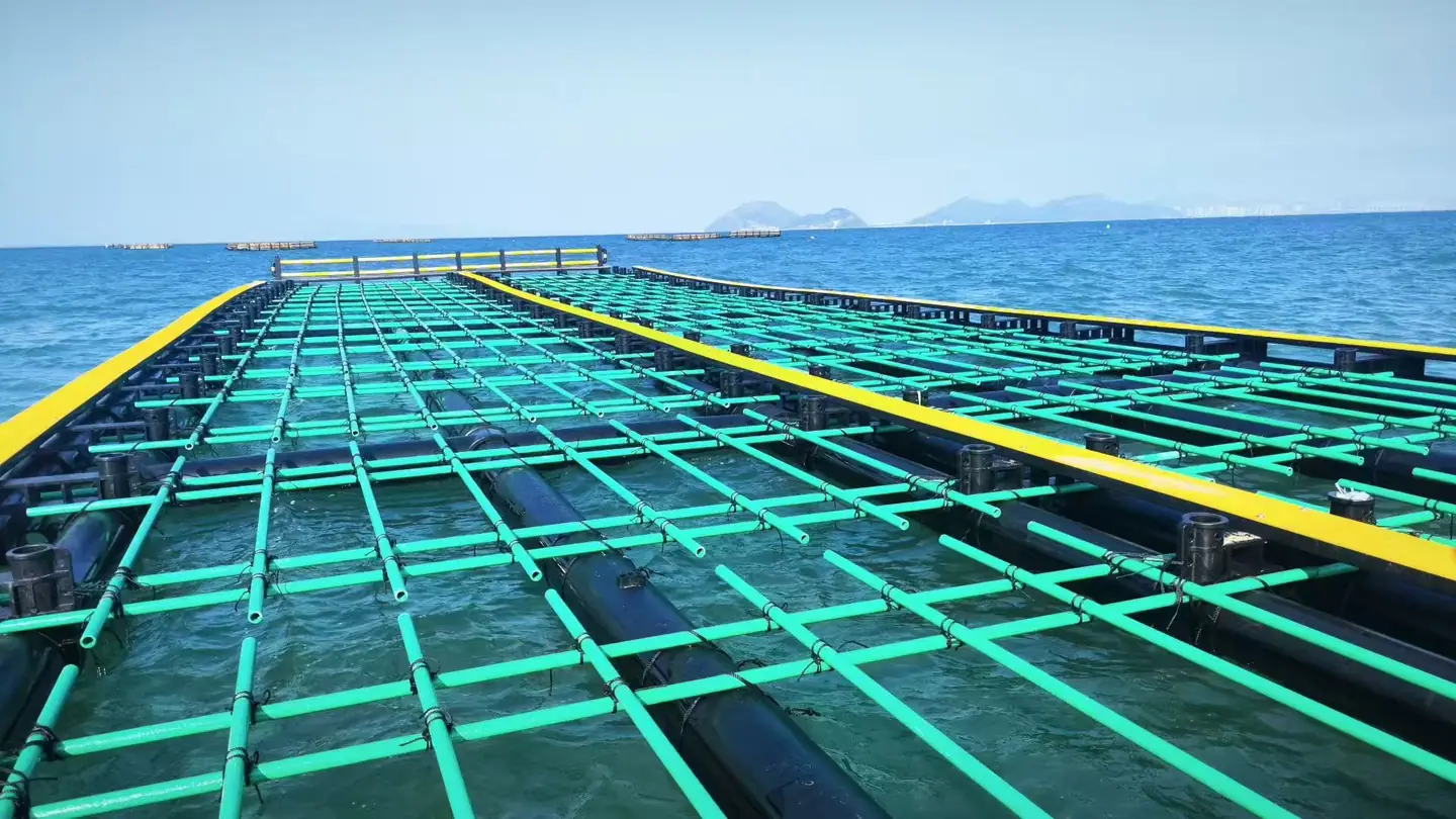 User-provided marine aquaculture application photo showing green FRP tubular profiles on a floating platform